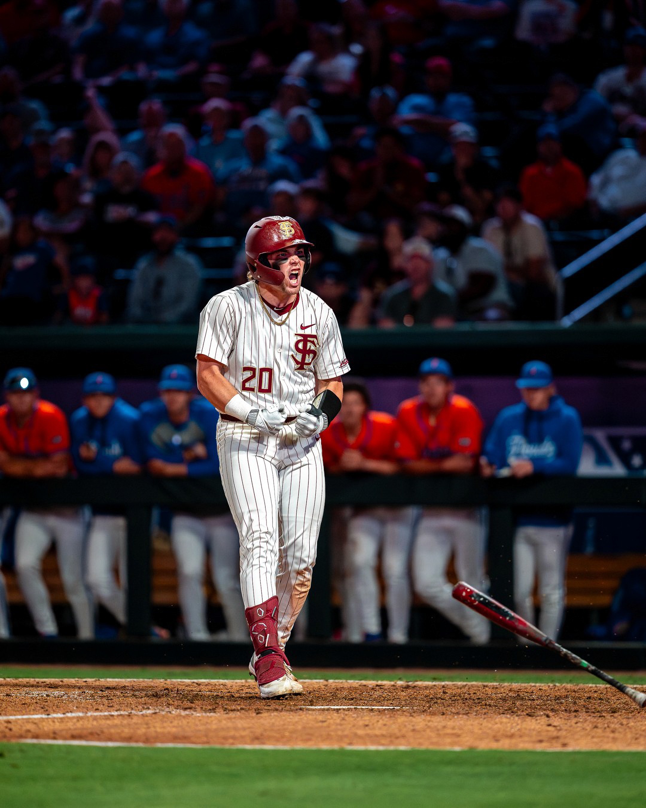 Florida State’s Jaxson West (20) lets the bat fly and shouts toward the dugout.