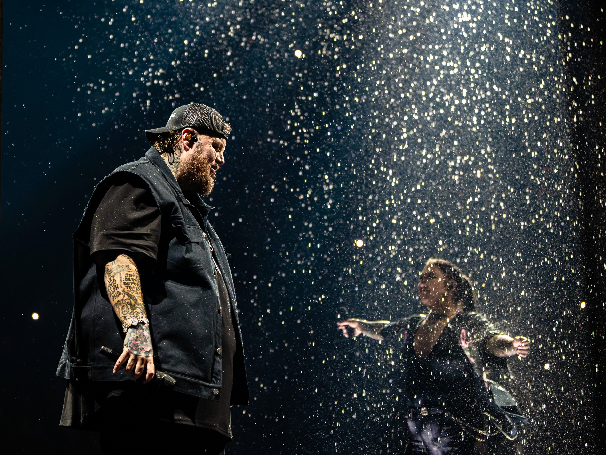 Jelly Roll under the sparkle rain with a guest singer across the stage.