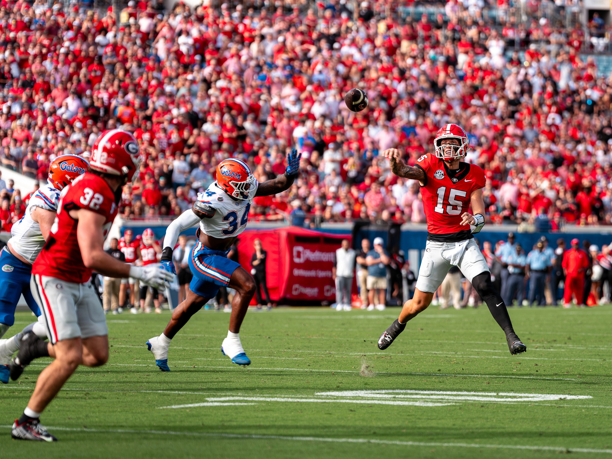 Georgia quarterback Carson Beck (15) releases a throw over a leaping Florida defender in the Florida–Georgia game at EverBank Stadium.
