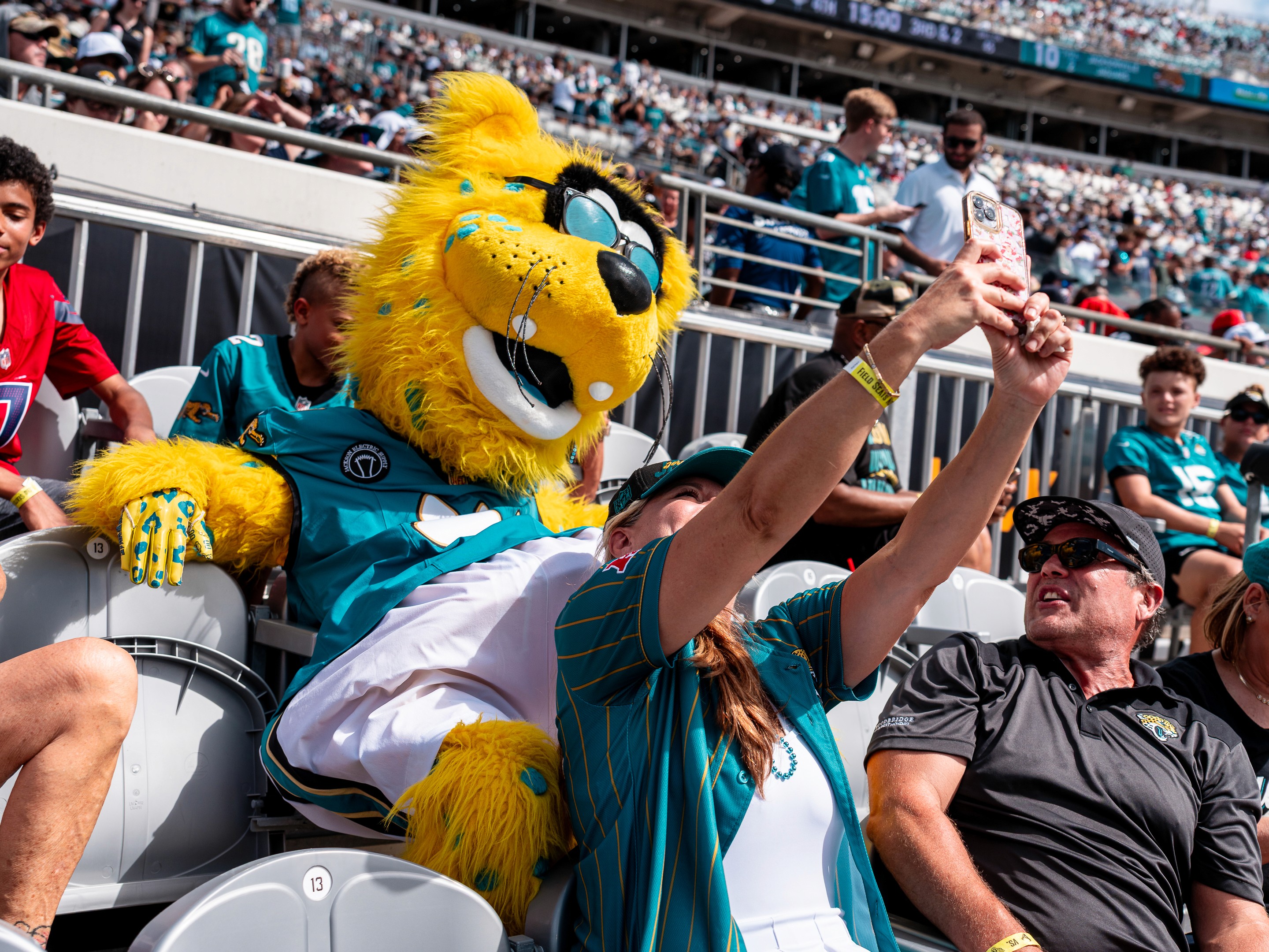 Jaxson de Ville poses for a selfie with fans in the stands.