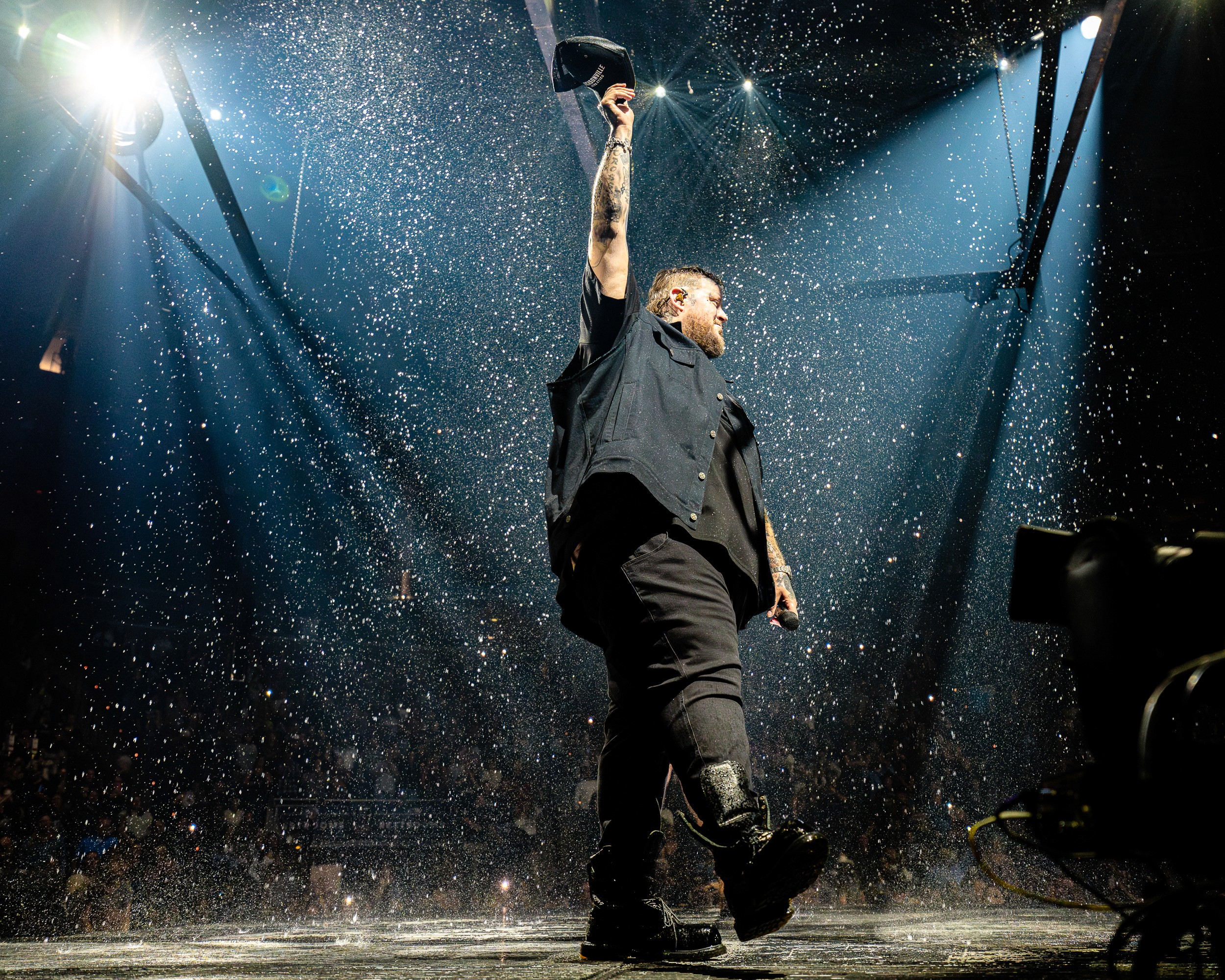 Jelly Roll under a shower of sparks, cap in the air, from the pit.