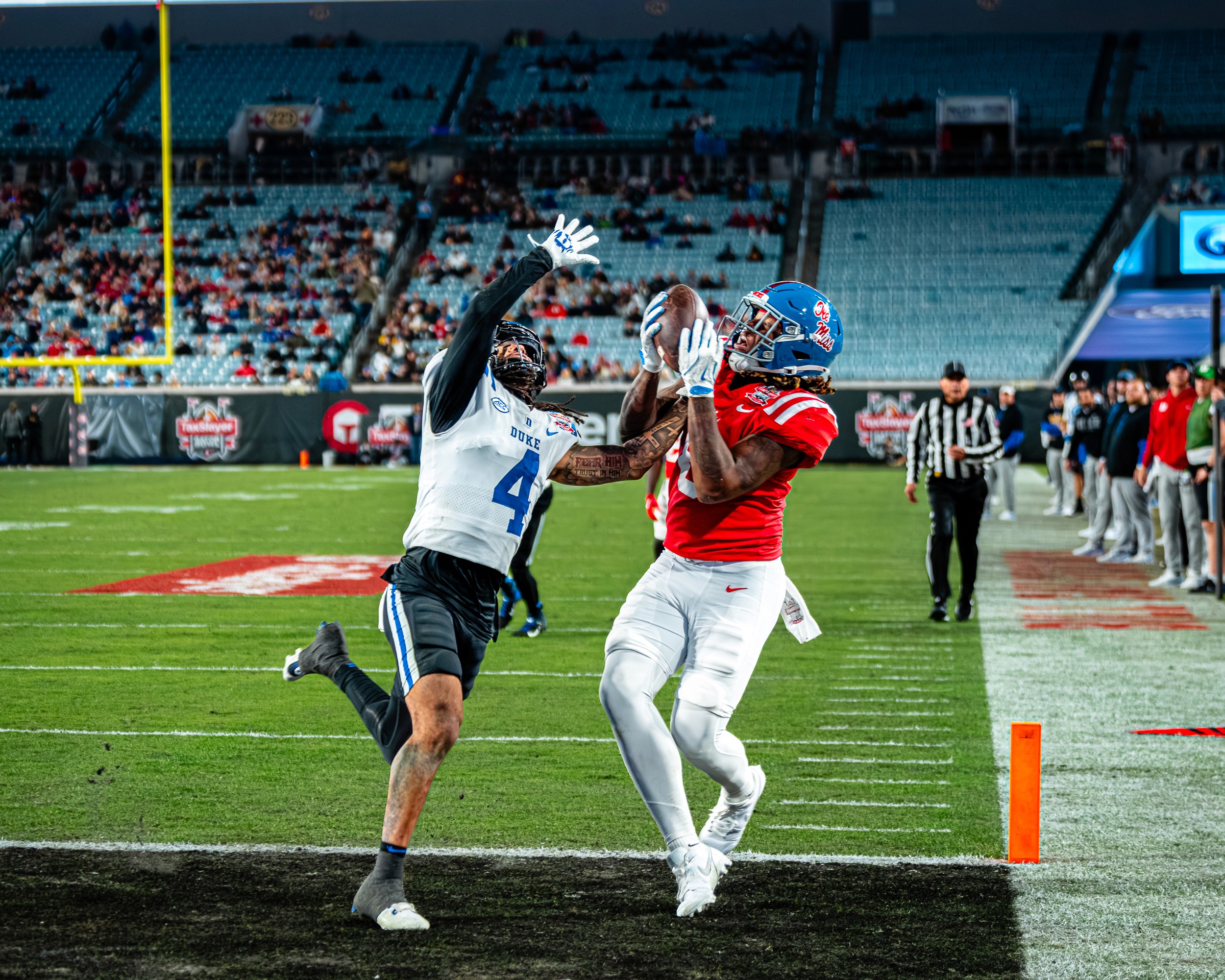 An Ole Miss receiver comes down with the ball over a Duke defender (4) at the front pylon.