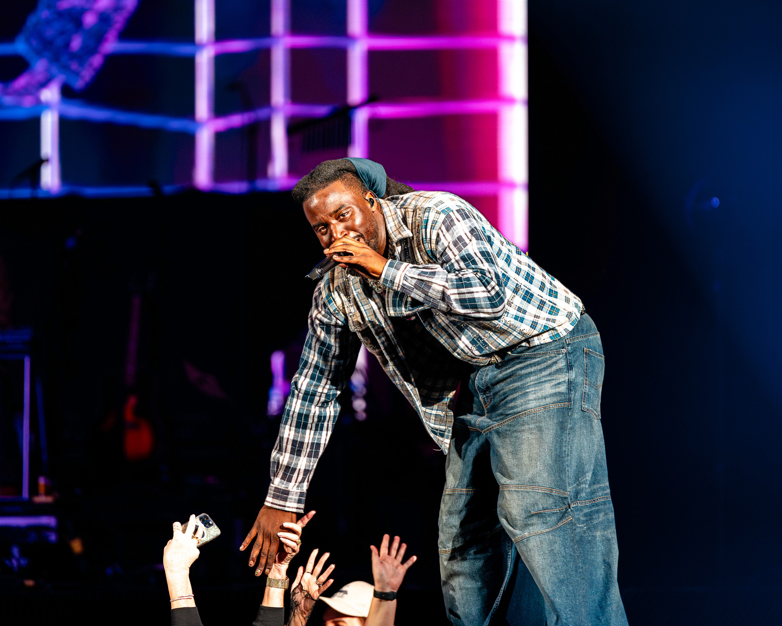 Shaboozey leans off the stage to slap hands with the front row at VyStar Veterans Memorial Arena.