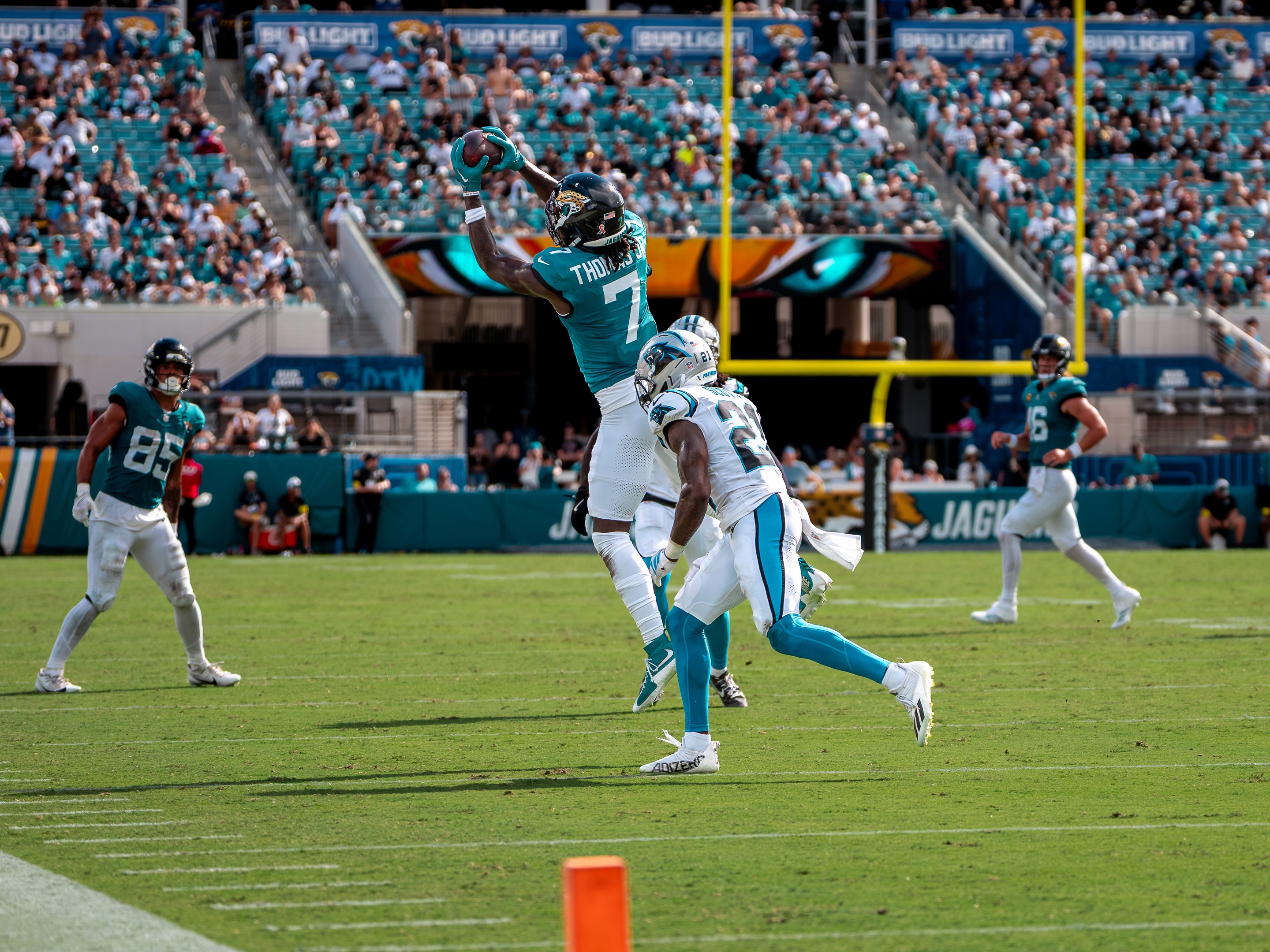 Brian Thomas Jr. (7) climbs over a Panthers cornerback for the catch, Brenton Strange (85) watching.
