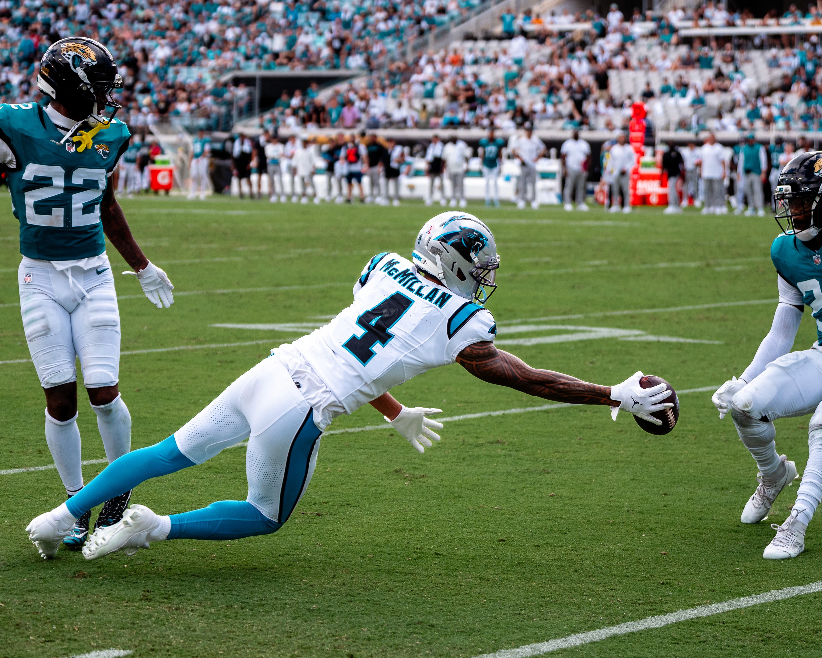 Panthers receiver Tetairoa McMillan (4) lays out for a catch in front of the Jaguars secondary.