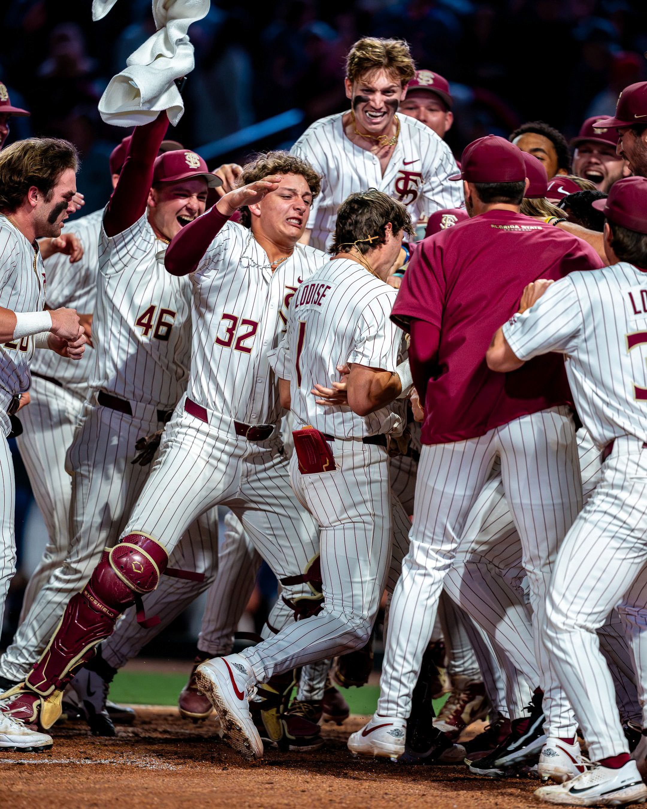Florida State mobs Alex Lodise at home plate after his walk-off grand slam against Florida at 121 Financial Ballpark.